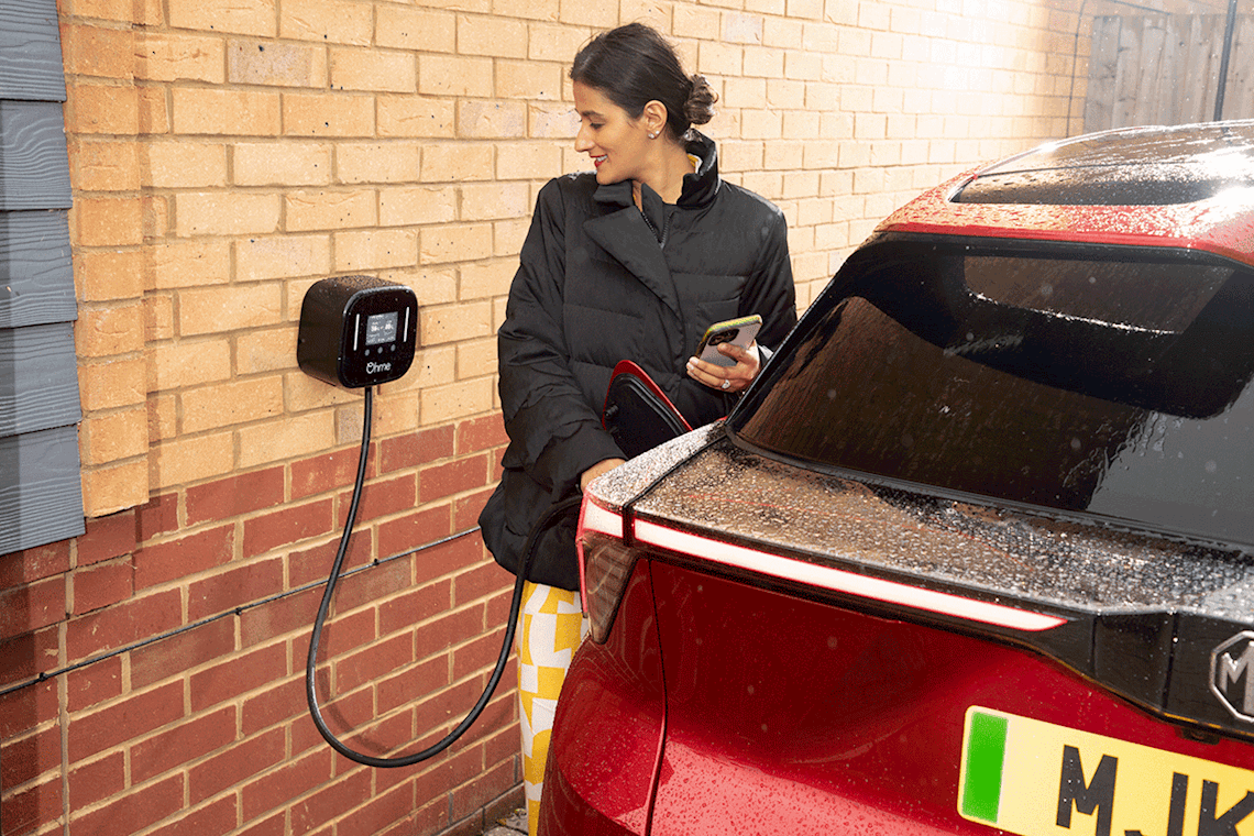 Woman charging electric car at home