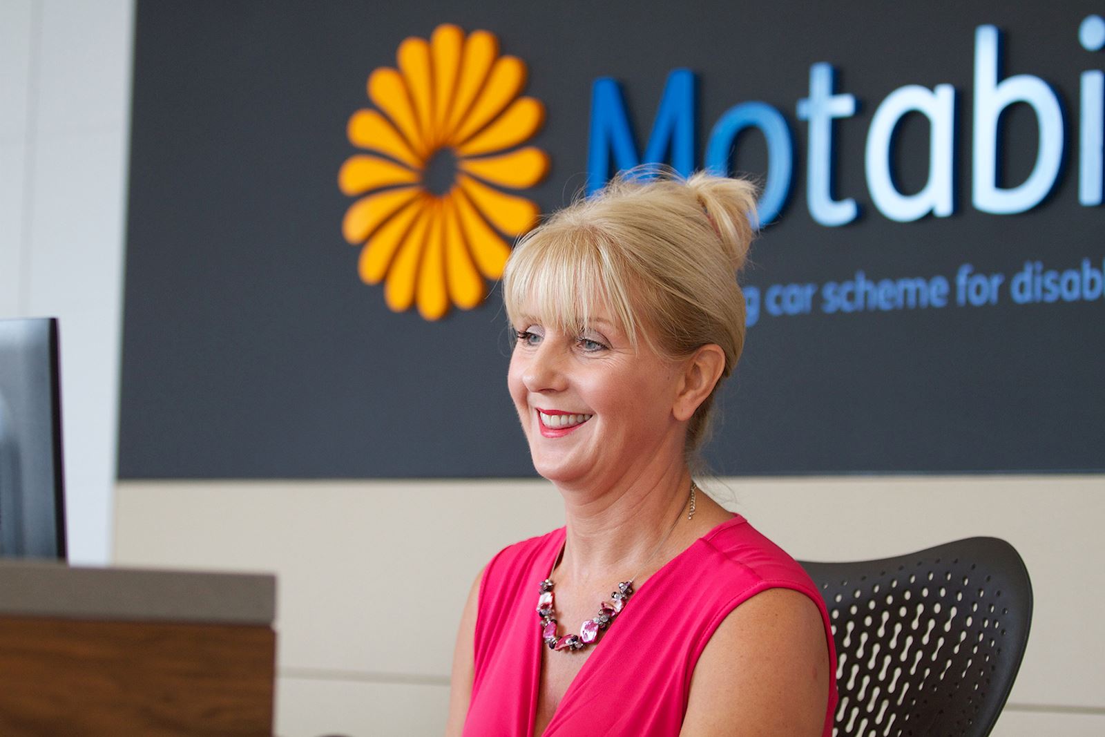A woman sits at a desk at Motability Operations