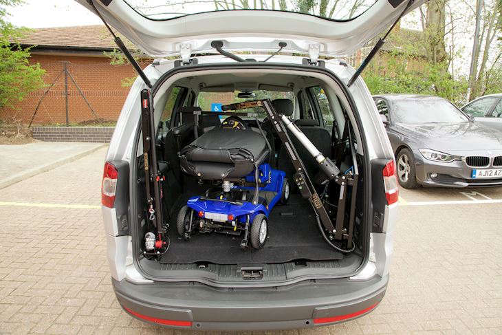 A folded mobility scooter in the boot of a car