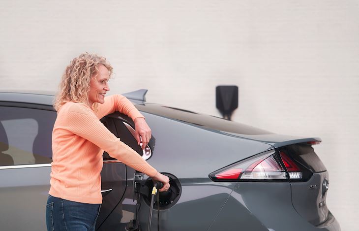 A woman charging an electric car
