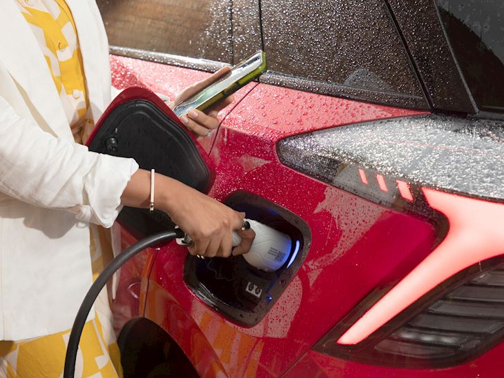 Woman charging red electric car