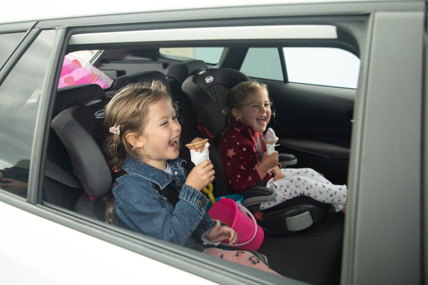 Two girls sitting in the car eating ice cream
