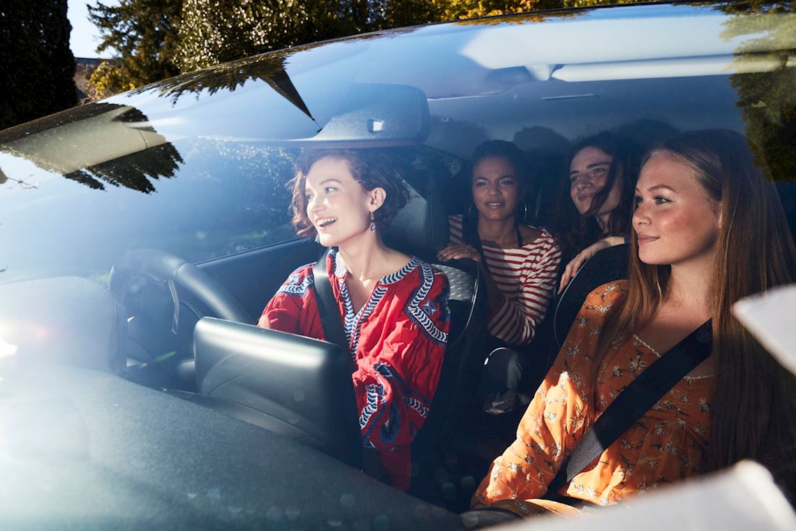 A group of women sitting inside a car