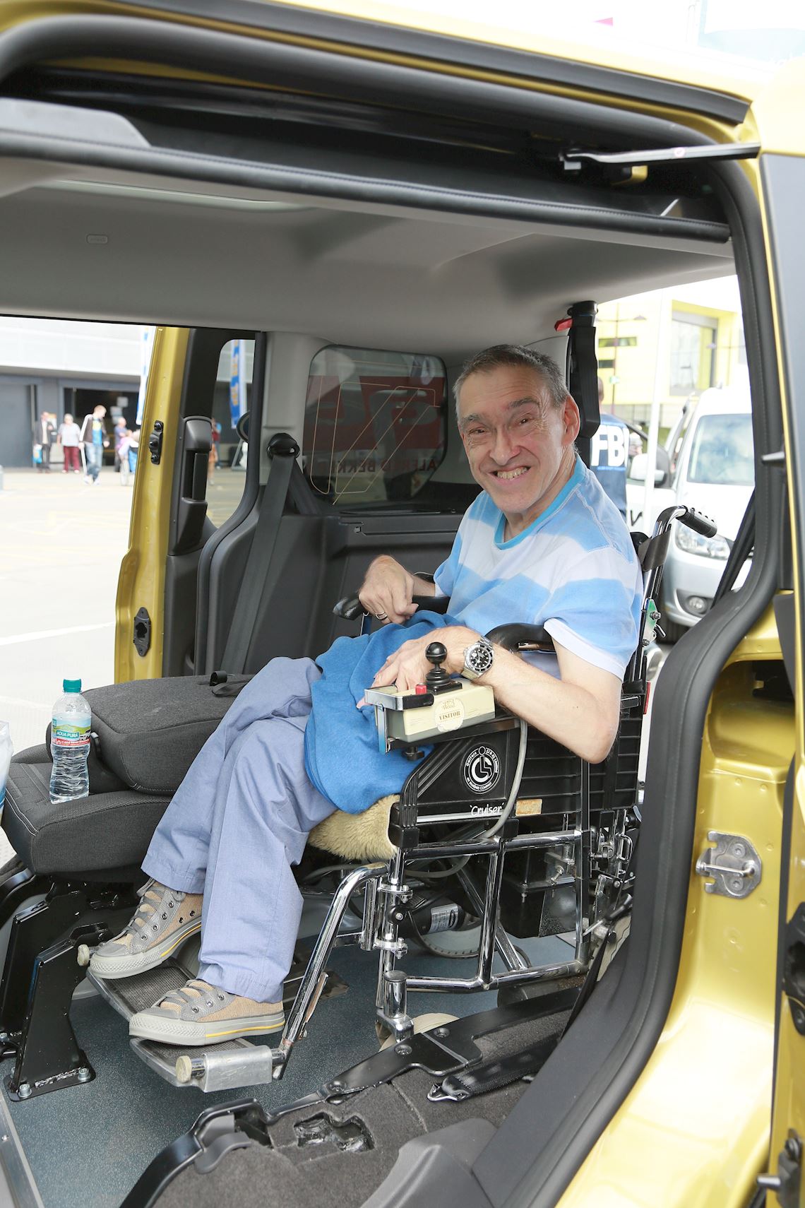 A man smiling in a wheelchair, inside a WAV