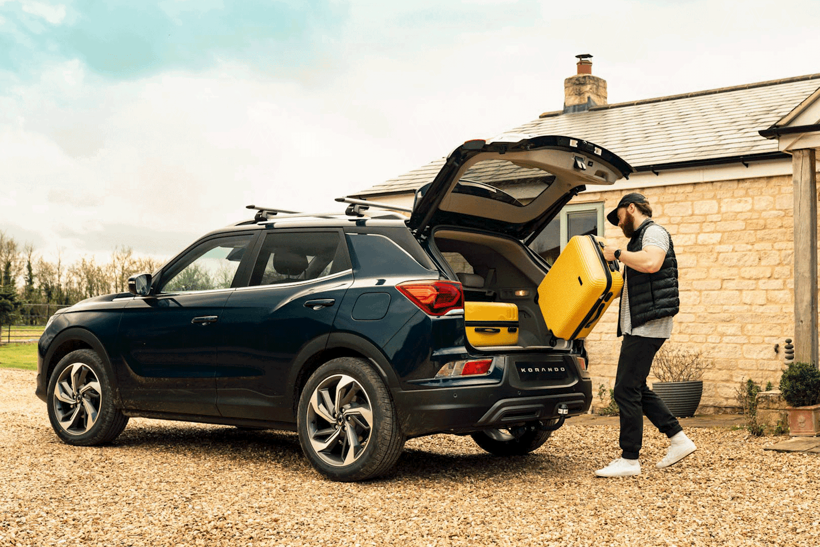 KGM Korando with man placing suit case in the boot