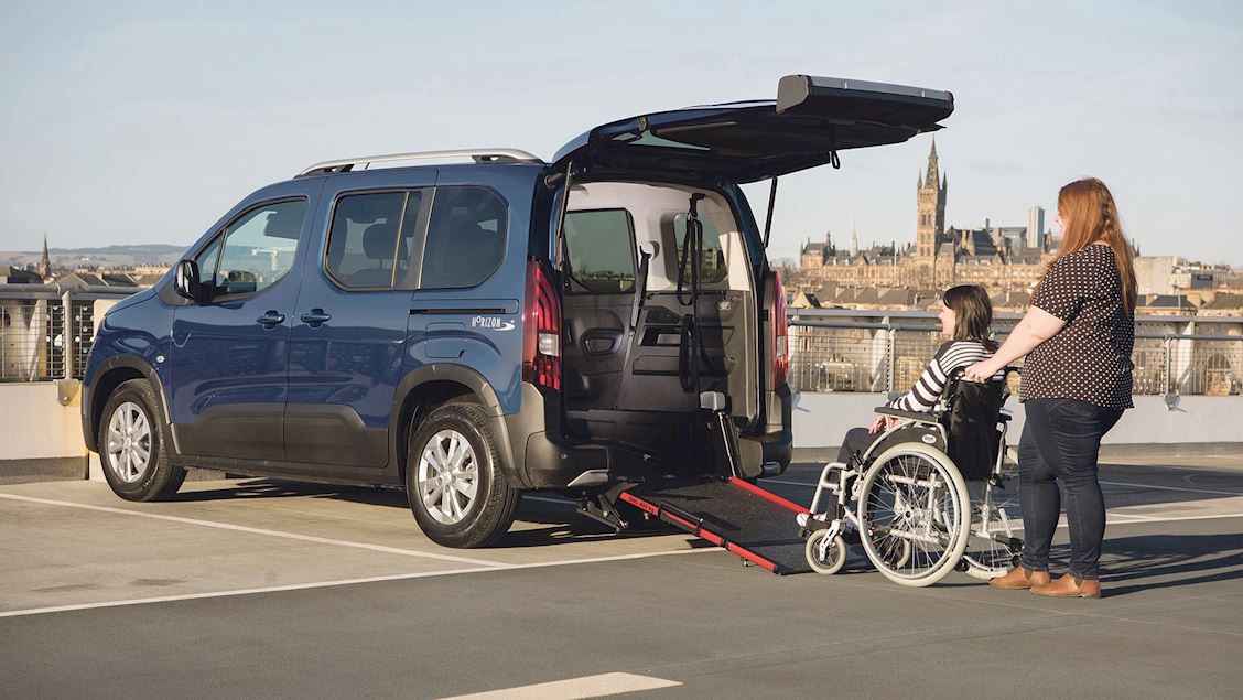 A lady on a wheelchair entering a Wheelchair Accessible Vehicle