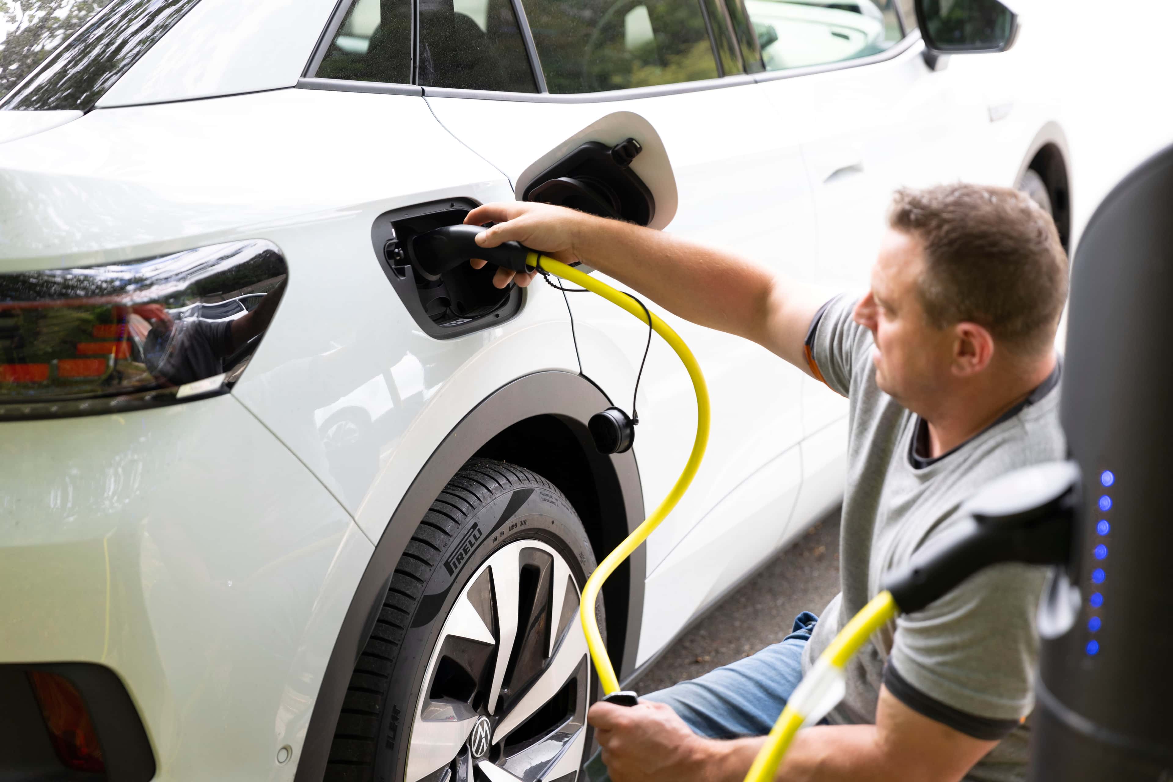 A man charging white electric car