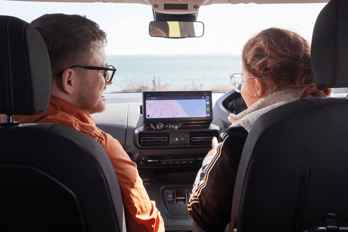 A man and a woman sat in their parked car