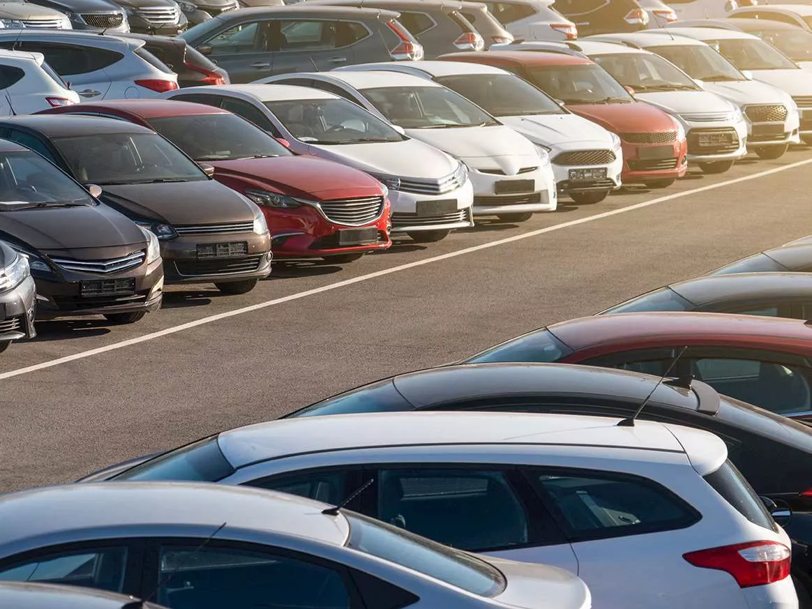 An image of several cars, all different shapes and sizes, in a car park