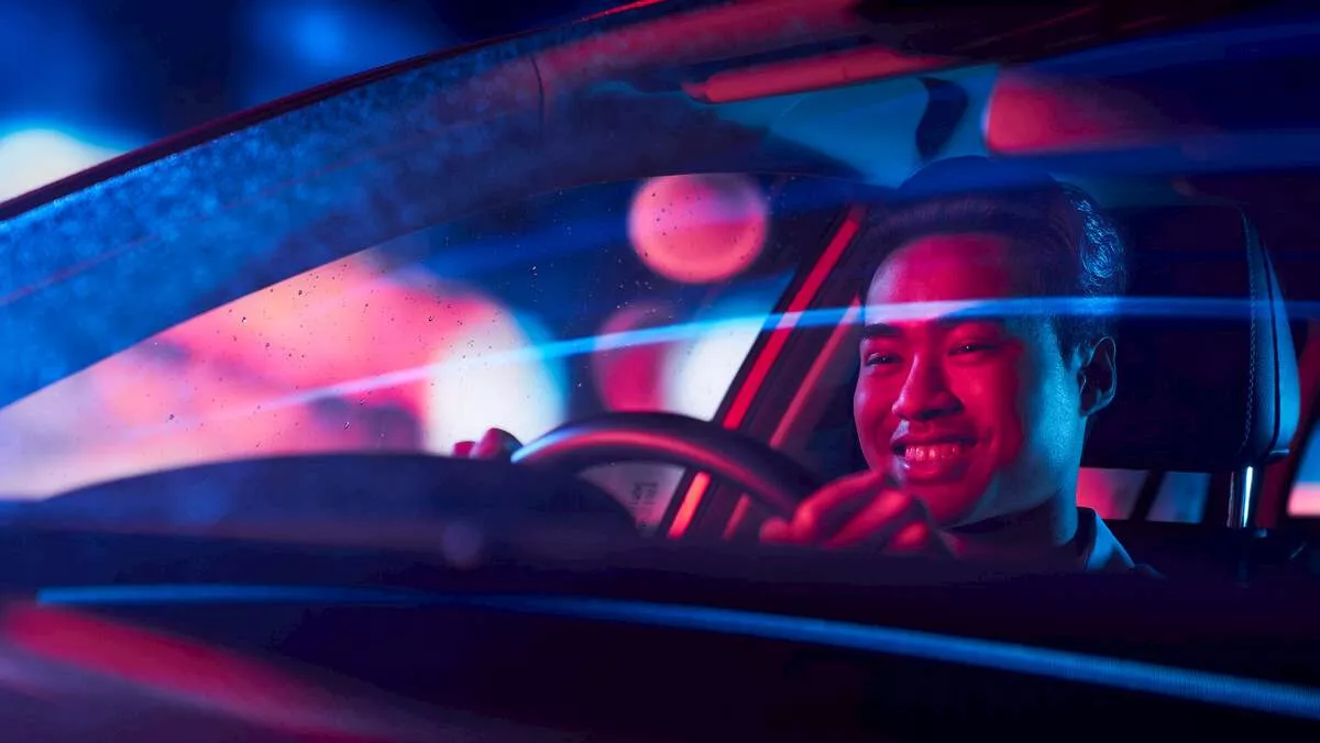 A man driving an electric car at night