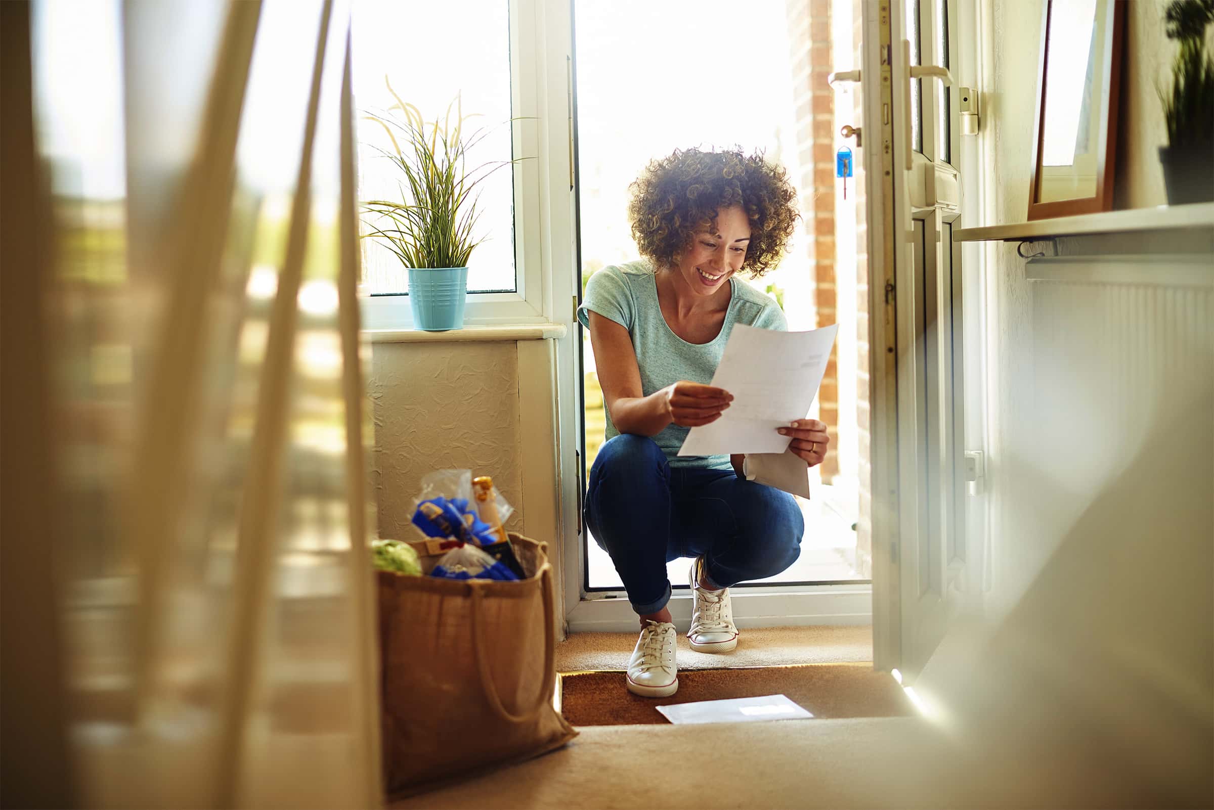 A woman opening an envelope received in the post