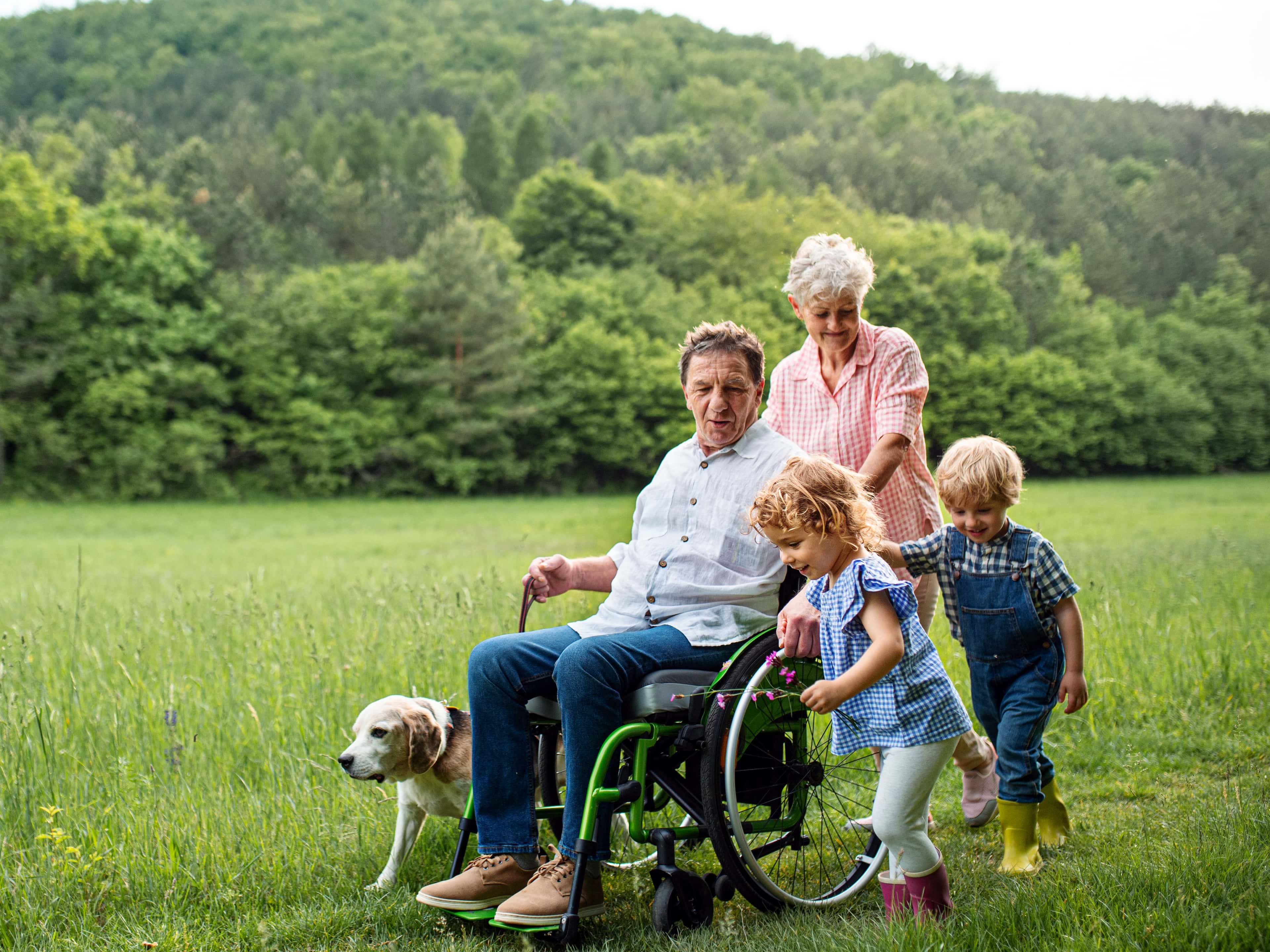 A family and a wheelchair user in a field
