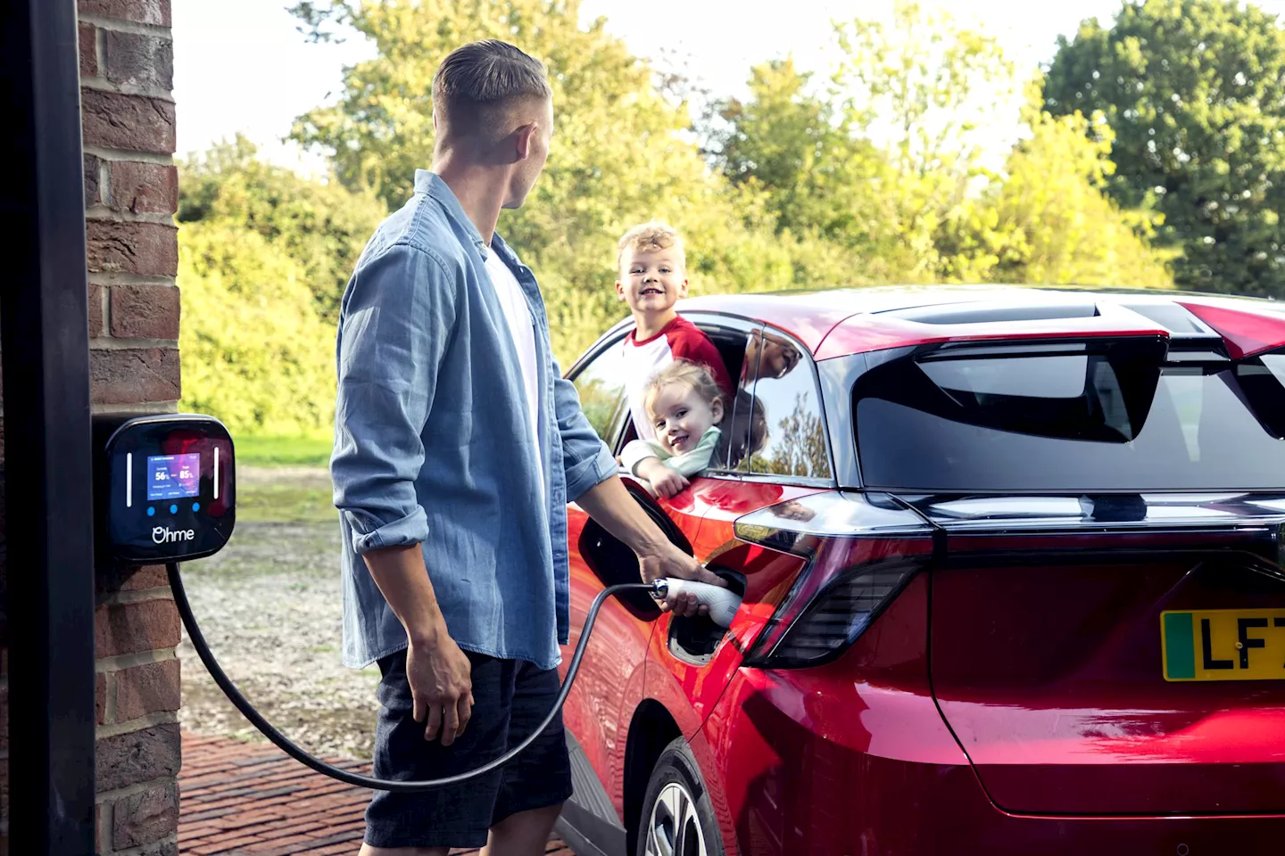 Man charging his electric car at home in his driveway