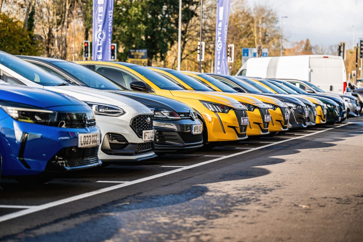 cars of different sizes and colours parked at a car dealership