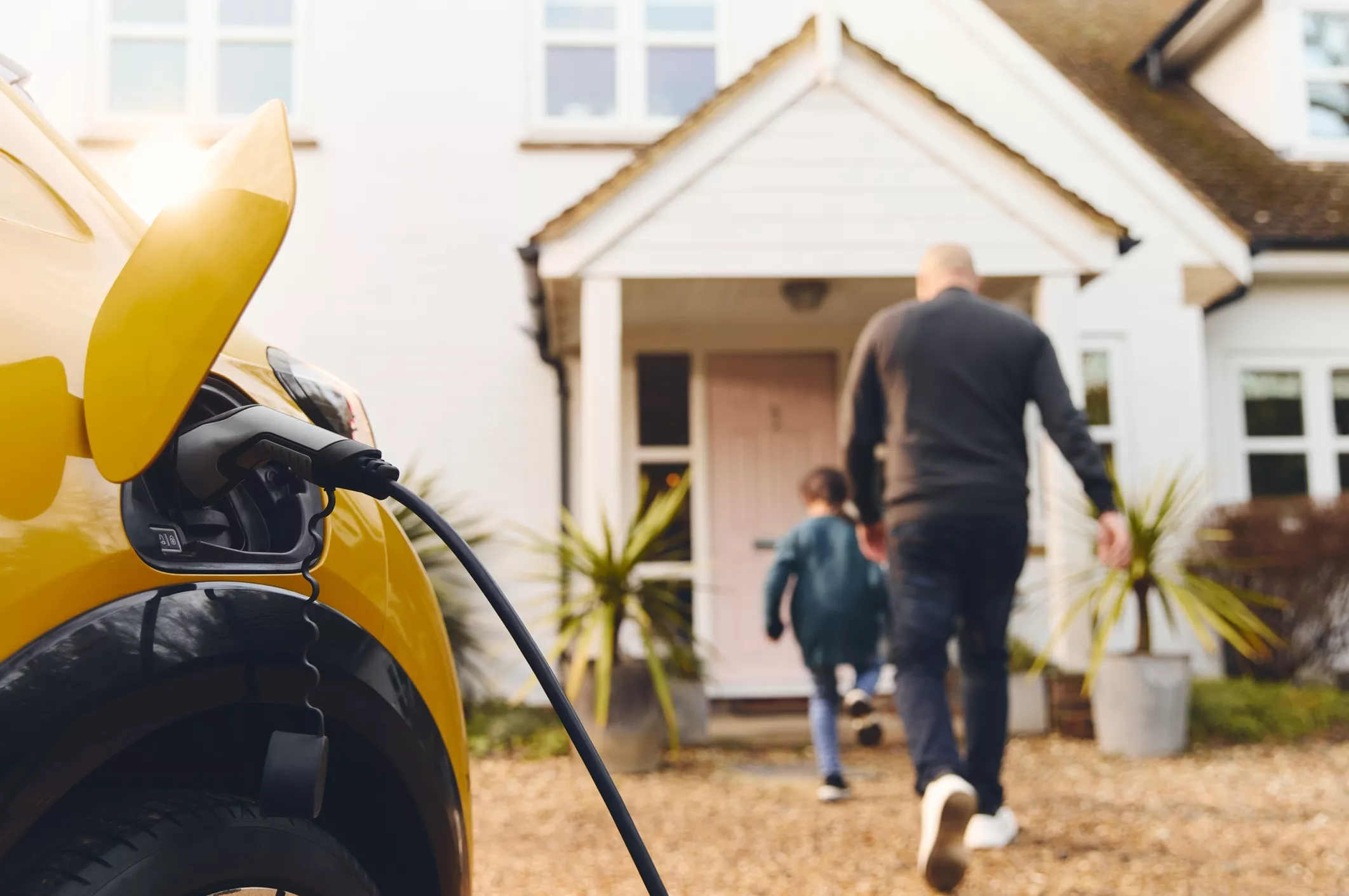 Family walking away from charging EV