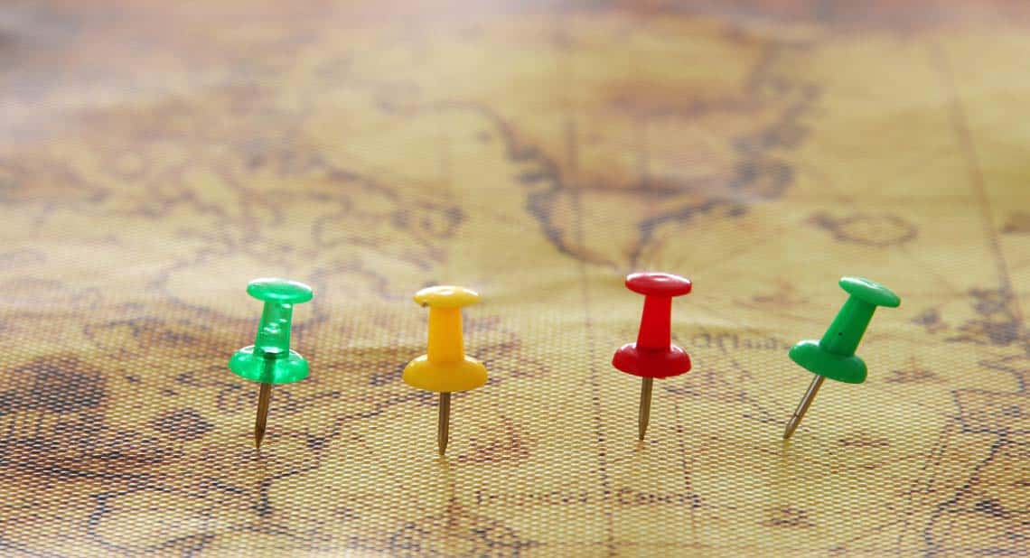 Image of pins attached to map, showing location or travel destination.