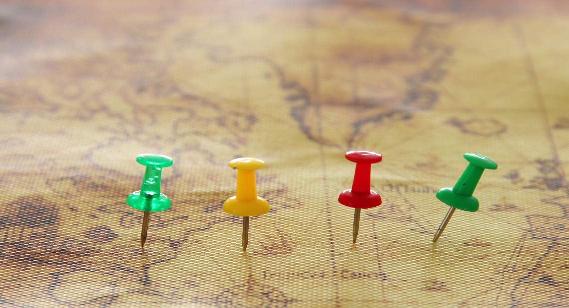 Image of pins attached to map, showing location or travel destination.